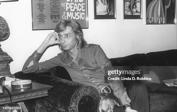 American singer Barry Manilow speaks with an interviewer in his Manhattan apartment, 26th December 1973. With him on the couch is his beagle, Bagel;...