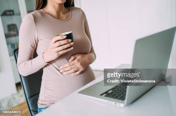 pregnant woman working from home. - parental leave stock pictures, royalty-free photos & images