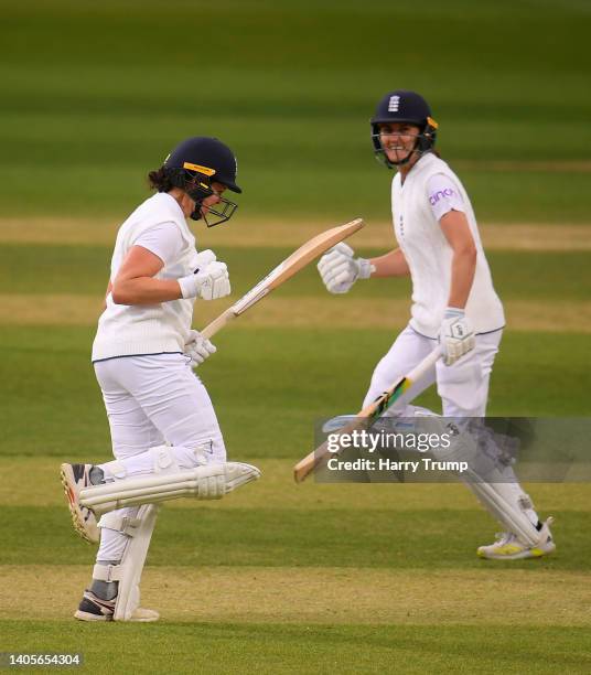 Alice Davidson-Richards of England celebrates their century with team mate Nat Sciver during Day Two of the First Test Match between England Women...