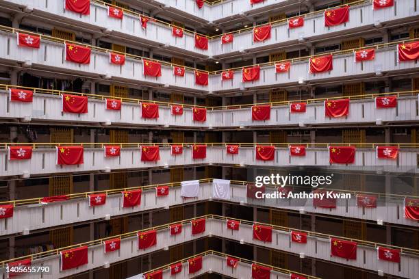 The Chinese national and Hong Kong flags are decorated at public housing building ahead of the 25th anniversary of Hong Kong handover on June 25,...