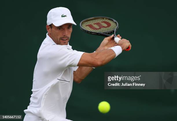 Roberto Bautista Agut of Spain plays a backhand against Attila Balazs of Hungary during their Men's Singles First Round Match on day two of The...