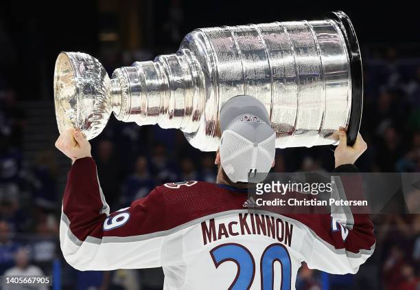 Nathan MacKinnon of the Colorado Avalanche kisses the Stanley Cup in celebration after Game Six of the 2022 NHL Stanley Cup Final at Amalie Arena on...