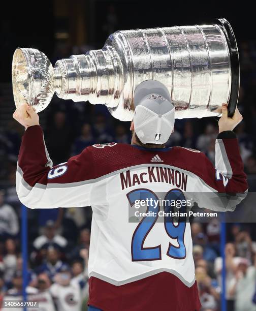 Nathan MacKinnon of the Colorado Avalanche kisses the Stanley Cup in celebration after Game Six of the 2022 NHL Stanley Cup Final at Amalie Arena on...