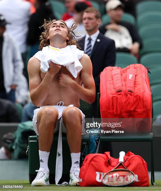 Stefanos Tsitsipas of Greece changes his shirt in the change over against Alexander Ritschard of Switzerland during their Men's Singles First Round...