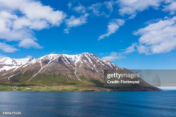 olafsfjordur is located in a fjord of the same name. surrounded by high snow covered mountains and with picturesque little harbor - iceland harbour stock-fotos und bilder