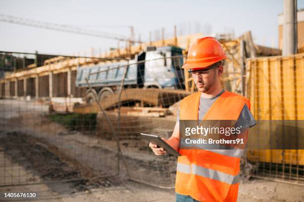 construction site foreman using a digital tablet computer - building confidence stock pictures, royalty-free photos & images