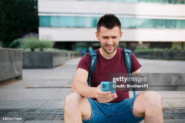 young adult student using a smart phone outdoors - amputee stock pictures, royalty-free photos & images