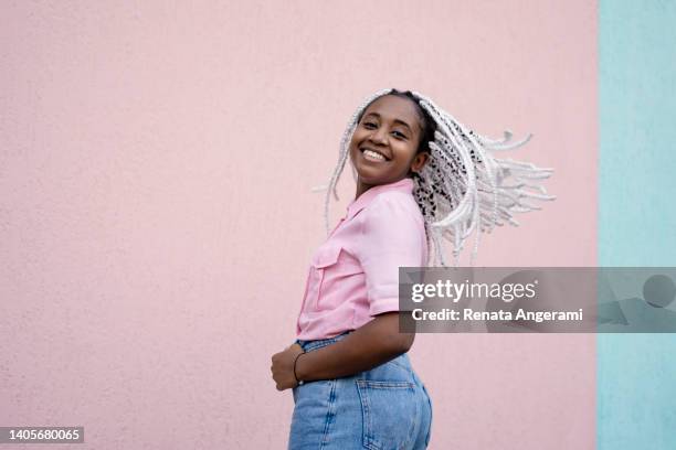 young woman swinging with braided white hair on pink background - braided hair imagens e fotografias de stock