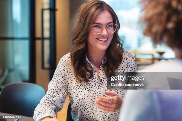business colleagues having a conversation. - two females stock pictures, royalty-free photos & images