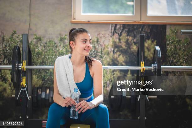 a woman drinks water during training. stock photo - athleticism stockfoto's en -beelden