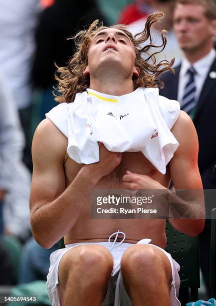 Stefanos Tsitsipas of Greece changes his shirt against Alexander Ritschard of Switzerland during their Men's Singles First Round match on day two of...