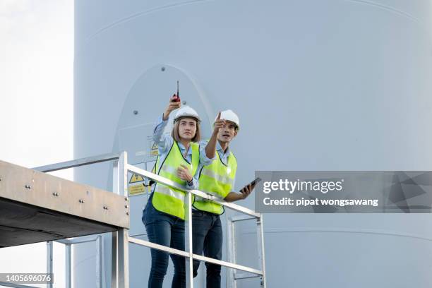 engineers in wind turbines are investigating the operation of wind turbines in wind farms. - airboard stock pictures, royalty-free photos & images