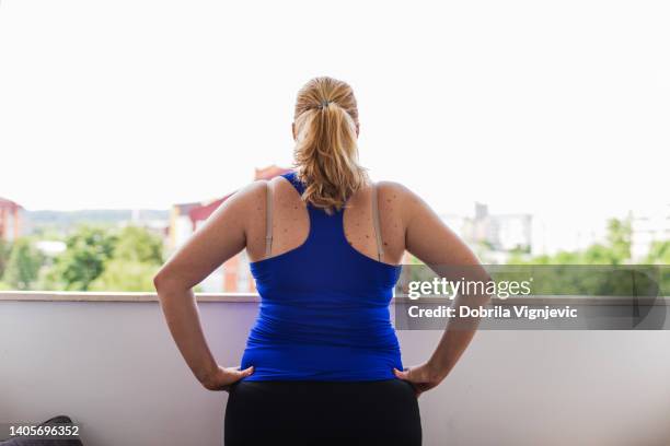 chubby woman doing warm up exercises on a balcony, rear view - morbidly obese woman 個照片及圖片檔