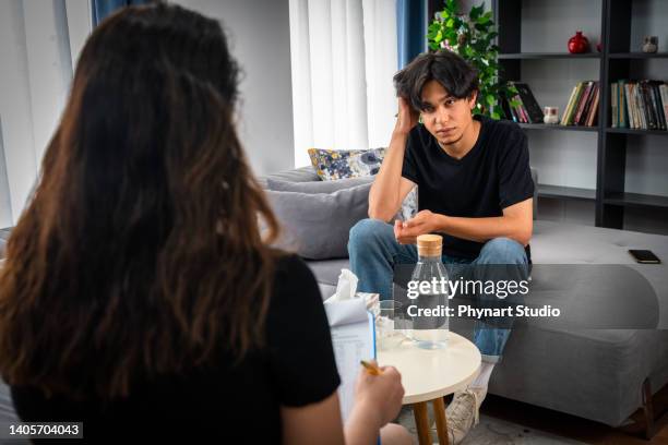 middle eastern teenager having psychotherapy session at psychologist's office - teen mental illness stock pictures, royalty-free photos & images