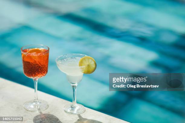 two cold fresh summer cocktails on poolside close-up. spritz and margarita - 瑪格麗特 個照片及圖片檔