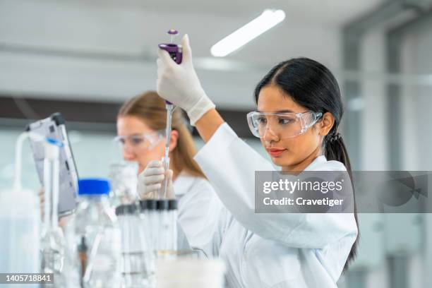 biologists put chemical liquid with the pipette in a test tube inside a laboratory. research and development concepts. - químico imagens e fotografias de stock