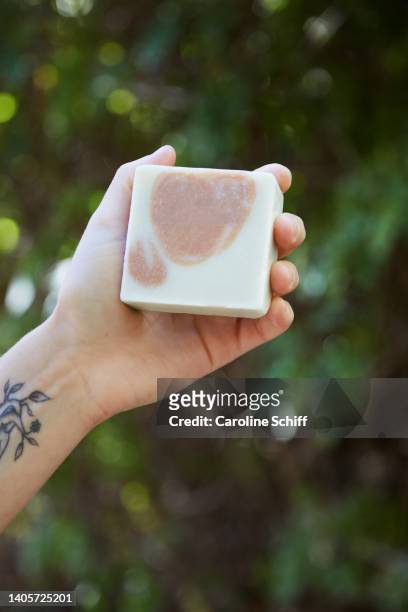 a woman's hand holding a bar of soap - barbade stock-fotos und bilder