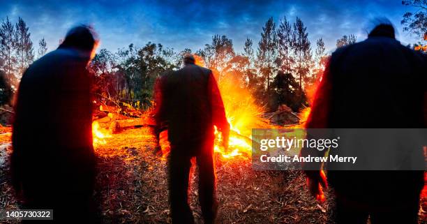 silhouetted men, forest fire at night, walking view - kolvandring bildbanksfoton och bilder