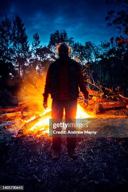 fire figure at night in dark forest - bonfire stock pictures, royalty-free photos & images