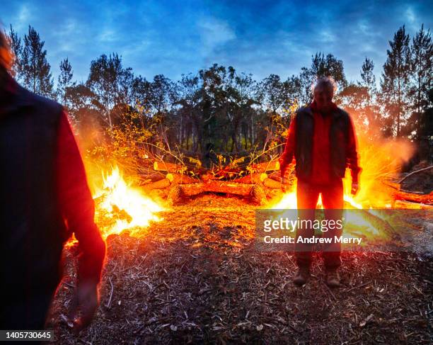 people in burning landscape at night - andrew eldritch stock-fotos und bilder