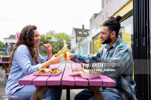 couple eating and drinking at a street restaurant and making a toast - mexican food and drink stock pictures, royalty-free photos & images