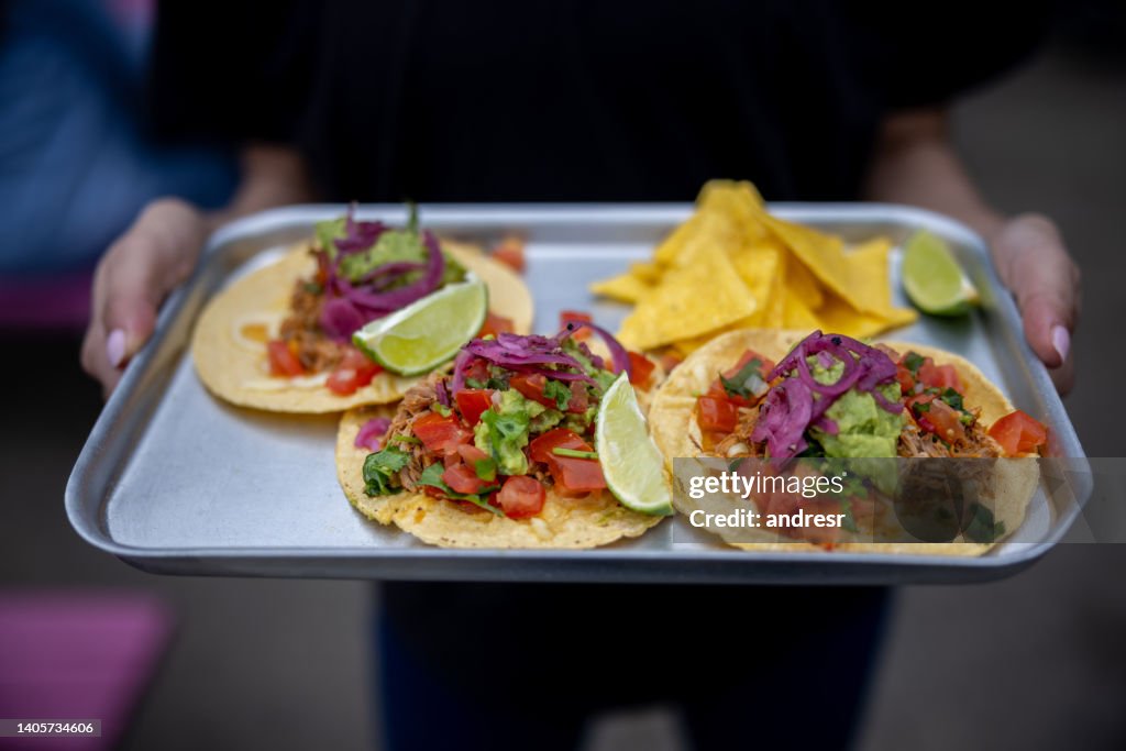 Close-up on a waitress serving tacos at a Mexican Restaurant