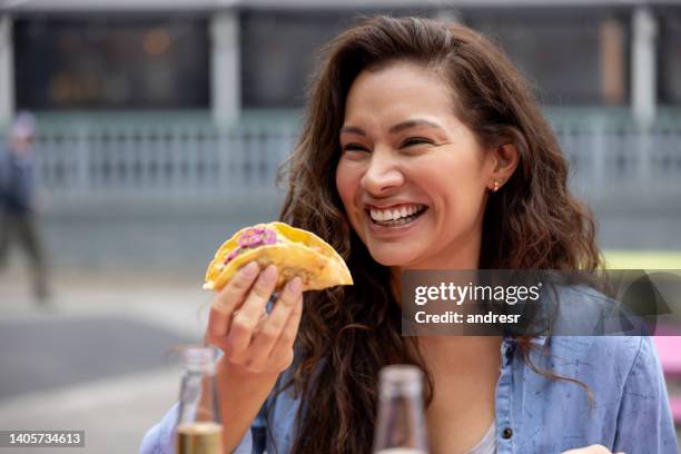 donna felice che mangia tacos in un ristorante di street food - cucina messicana foto e immagini stock