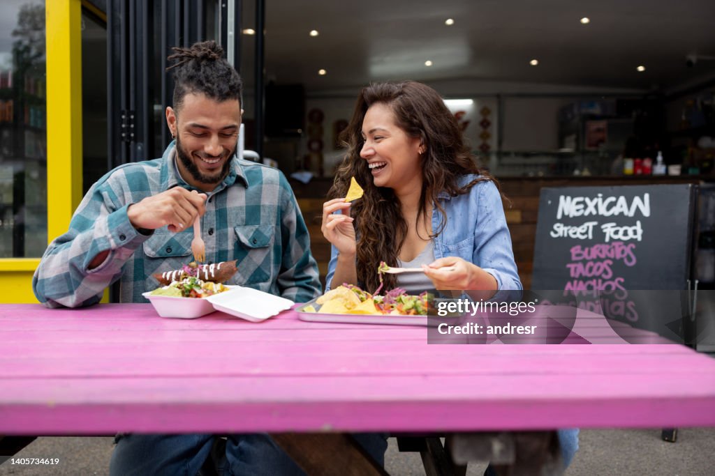 Loving couple looking happy eating tacos at a Mexican restaurant