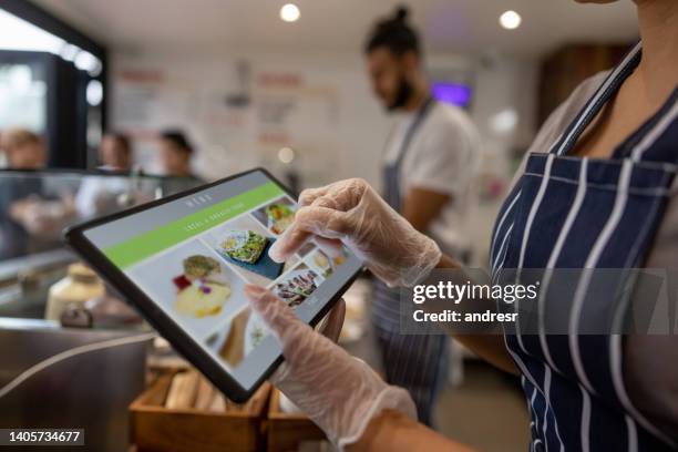 close-up on a waitress using a tablet to take an order at a restaurant - when britain went pop stock pictures, royalty-free photos & images