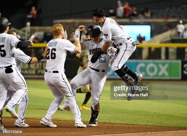 Christian Walker of the Arizona Diamondbacks celebrates his walk-off RBI fielder's choice with Josh Rojas and Pavin Smith and a 7-6 win over the San...