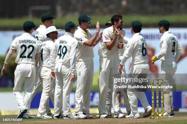 Mitchell Starc of Australia celebrates with teammates after dismissing Kusal Mendis during day one of the First Test in the series between Sri Lanka...