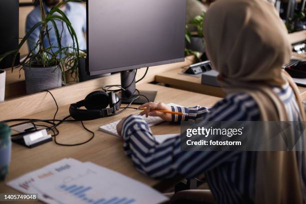 middle eastern businesswoman typing project data on computer keyboard - eastern europe bildbanksfoton och bilder