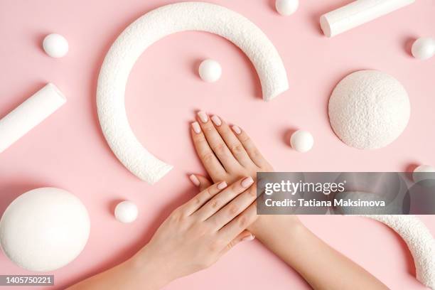 pink manicure and white abstract shapes on pink background, top view. - fingernail foto e immagini stock