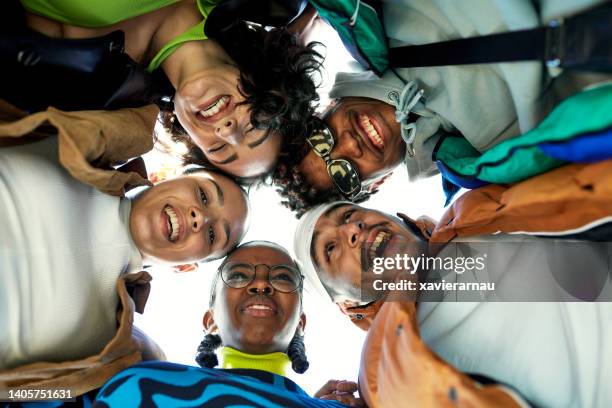 portrait of young friends huddling and laughing - southern european descent stock pictures, royalty-free photos & images