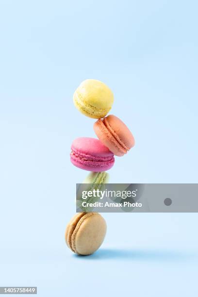 confitería, macarrones se equilibran sobre fondo azul - dessert sweet food fotografías e imágenes de stock