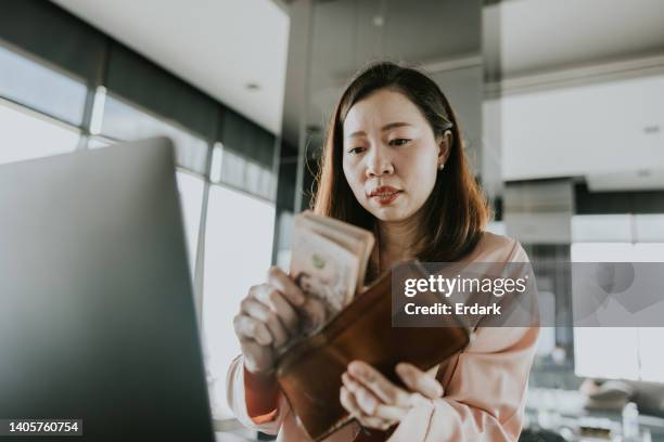 asian woman keeping her money from her salary into her wallet. - all asian currencies stock pictures, royalty-free photos & images