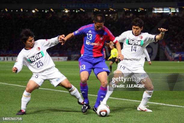 Sota Hirayama of FC Tokyo controls the ball under pressure of Yasushi Endo and Lee Jung-soo of Kashima Antlers during the J.League J1 match between...