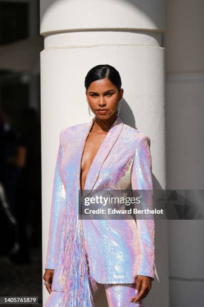 Guest wears diamonds pendant earrings, a pink shiny embroidered sequined blazer jacket with embroidered fringed details, matching pink shiny...