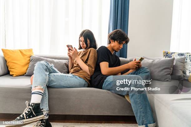 jealous girlfriend spying her boyfriend's phone - boy girl stockfoto's en -beelden