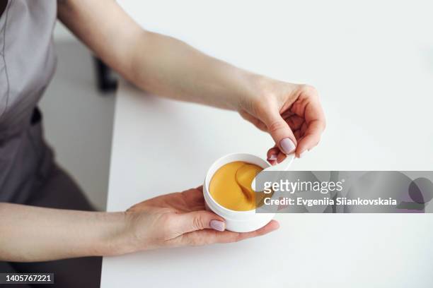 close up beautician's hands holding patches for eyes care. - one eyed stock pictures, royalty-free photos & images