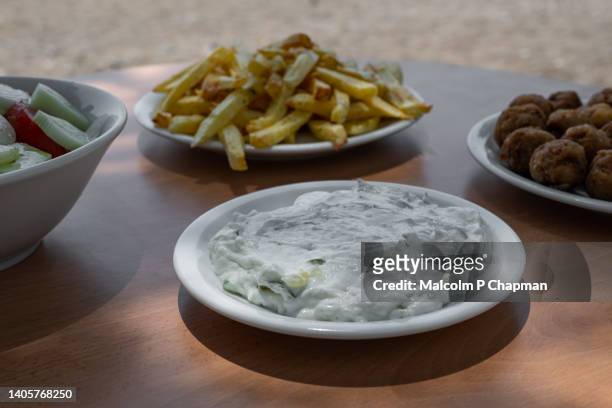 greek food - tzatziki - lunch by the sea, lesvos, greece - griekse gerechten stockfoto's en -beelden