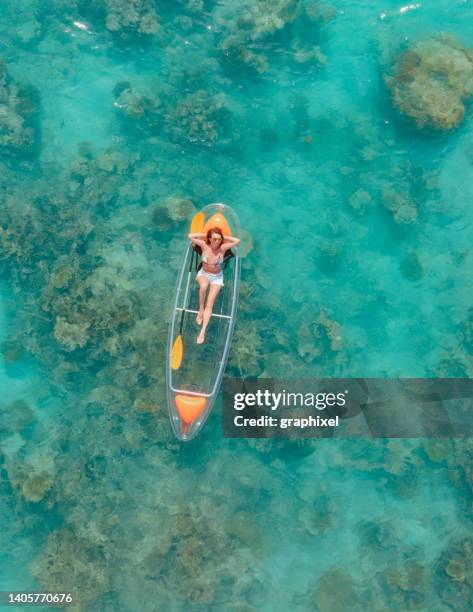 bella donna che gode della sua vacanza sul kayak con fondo di vetro nell'oceano tropicale - maldives sport foto e immagini stock