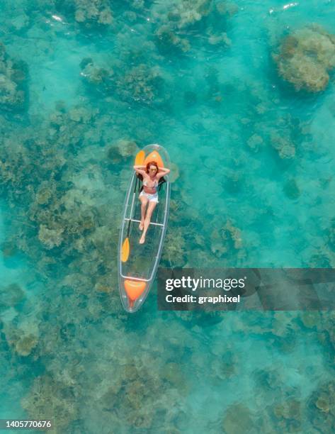 beautiful woman enjoying her vacation on glass bottom kayak in tropical ocean - maldives sport stock pictures, royalty-free photos & images