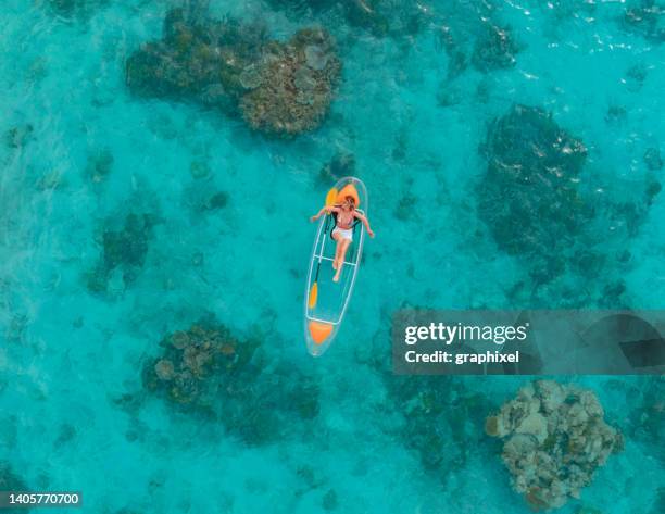 beautiful woman enjoying her vacation on glass bottom kayak in tropical ocean - maldives sport stock pictures, royalty-free photos & images