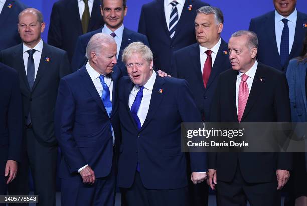 President Joe Biden chats with British Prime Minister Boris Johnson as Turkish President Recep Tayyip Erdogan looks on during a family photo at the...