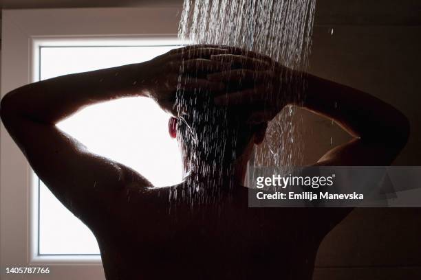 close-up of a young man in the shower - wasser ressource stock-fotos und bilder