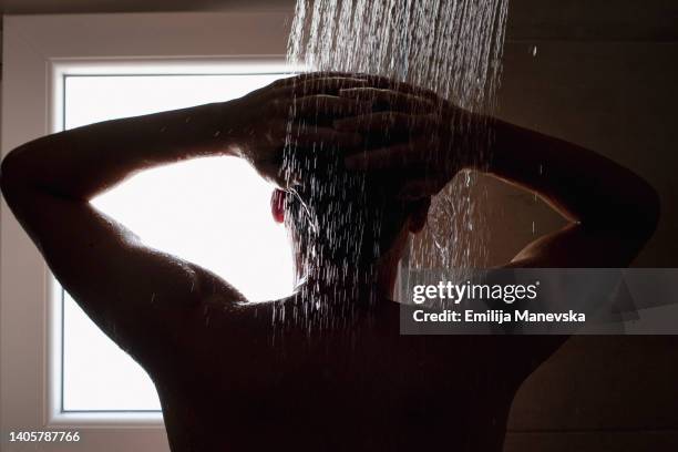 close-up of a young man in the shower - men taking a shower stockfoto's en -beelden