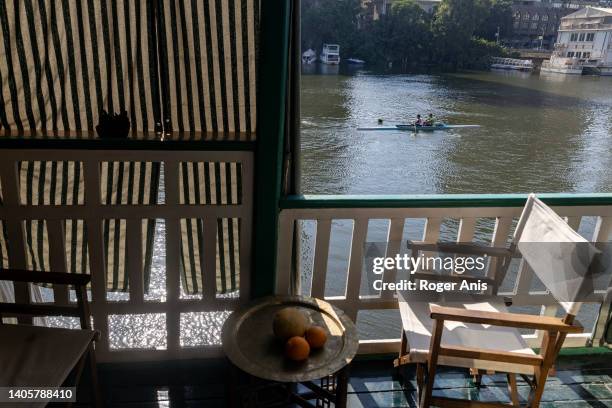 View from one of the houseboats by Imbaba corniche facing Zamalek Neighborhood while people rowing in the Nile, Houseboat 65 is one of many...