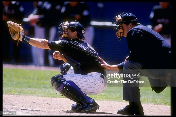 Catcher Joe Girardi of the Colorado Rockies waits to catch the ball during a game against the Florida Marlins at Coors Field in Denver, Colorado....