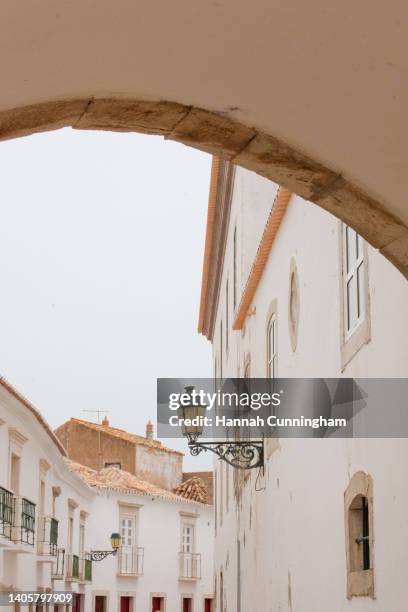 under the archway in the old town - faro city portugal stock-fotos und bilder